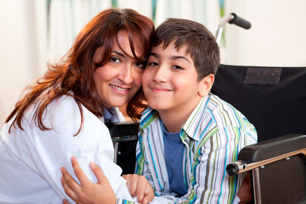 mother hugging her son in a wheelchair